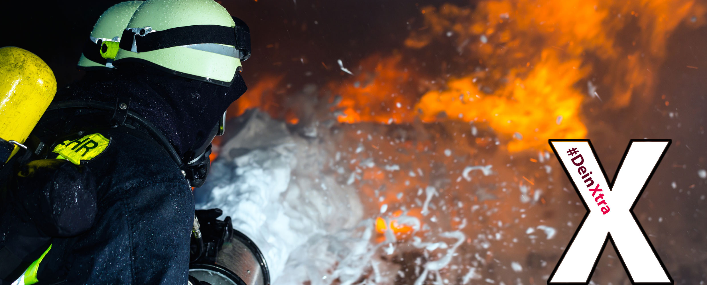 Bild zeigt Feuerwehrleute beim Löschen eines Brandes und das Logo #DeinXtra.